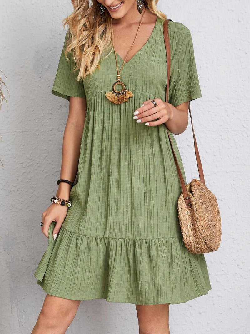 Elegant dress with soft layered detailing and a gently draped waist.