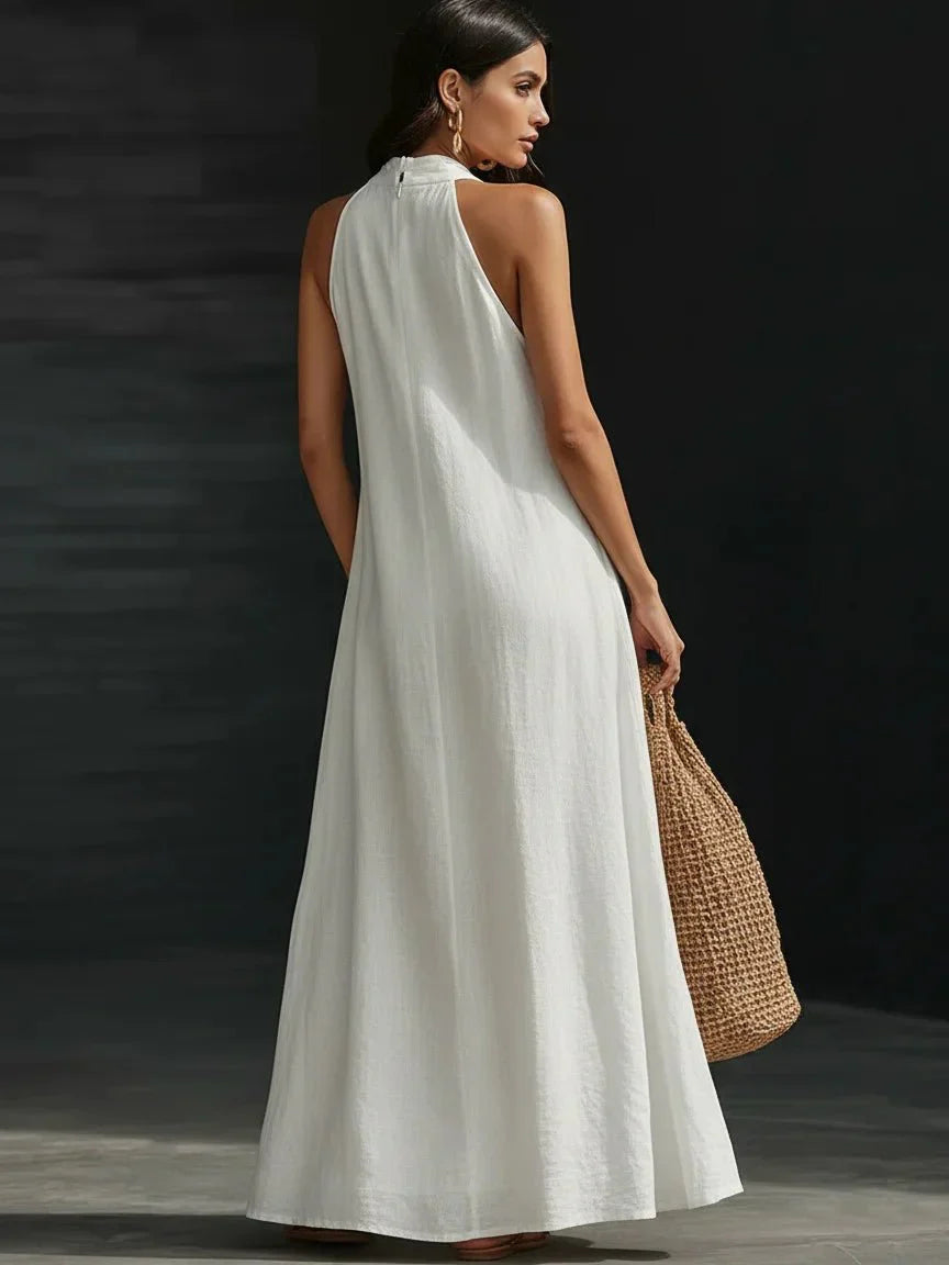 Linen-blend halter maxi dress with a fluid A-line skirt and side pockets, styled for warm weather.