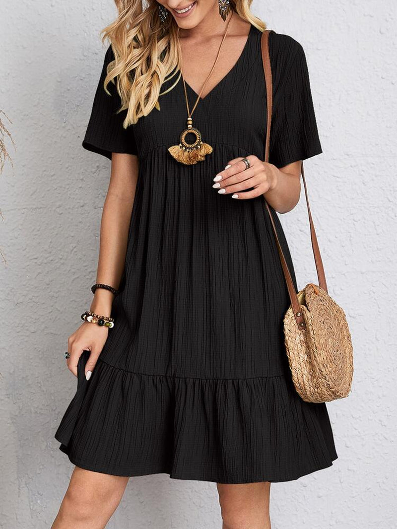 Elegant dress with soft layered detailing and a gently draped waist.
