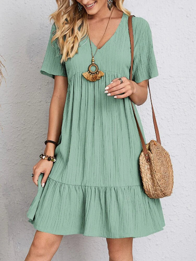 Elegant dress with soft layered detailing and a gently draped waist.