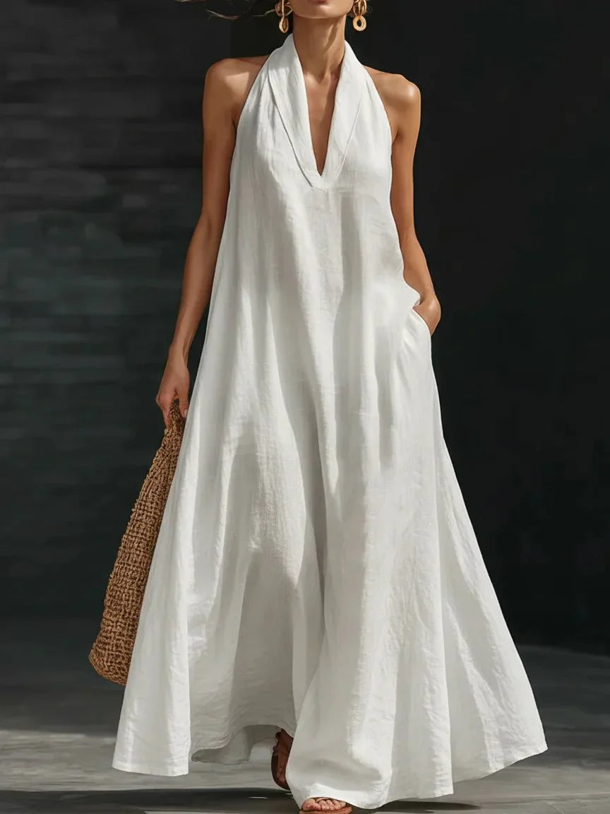 Linen-blend halter maxi dress with a fluid A-line skirt and side pockets, styled for warm weather.