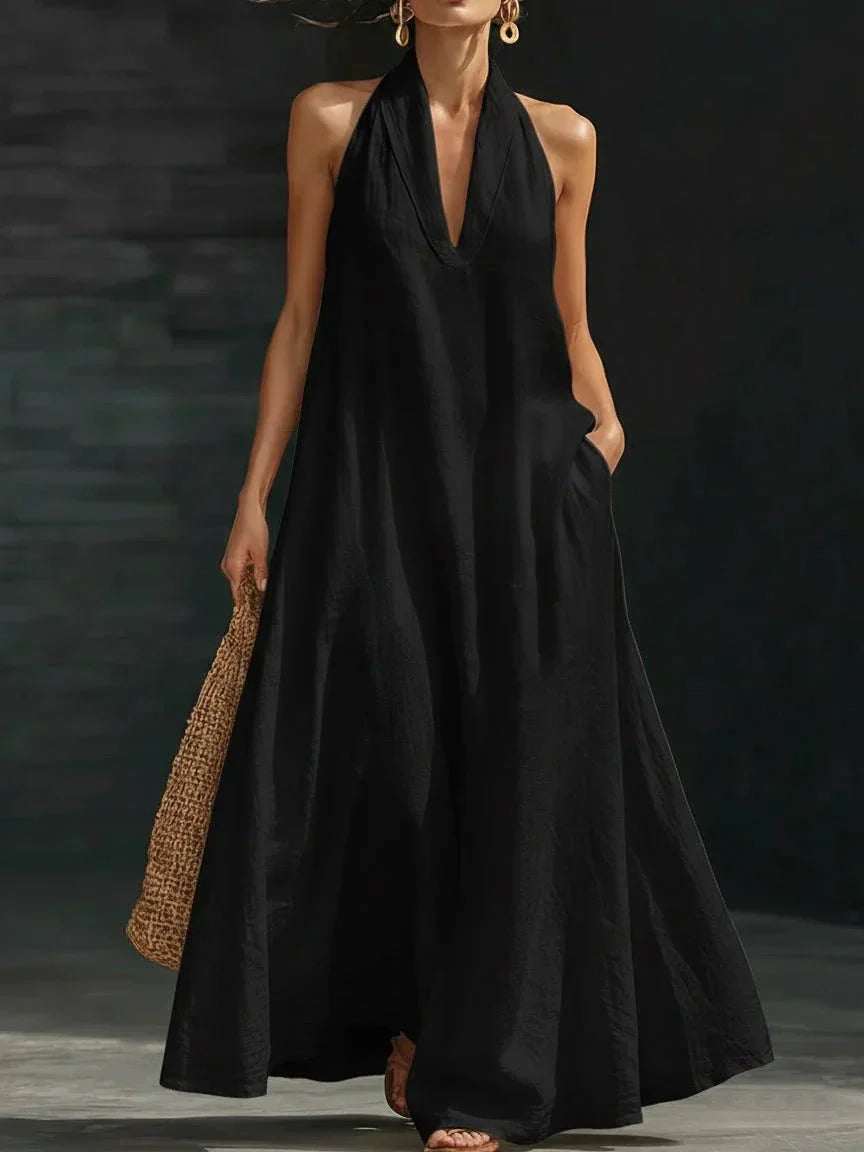 Linen-blend halter maxi dress with a fluid A-line skirt and side pockets, styled for warm weather.