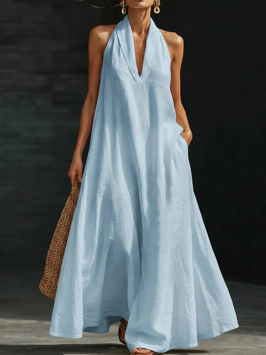 Linen-blend halter maxi dress with a fluid A-line skirt and side pockets, styled for warm weather.