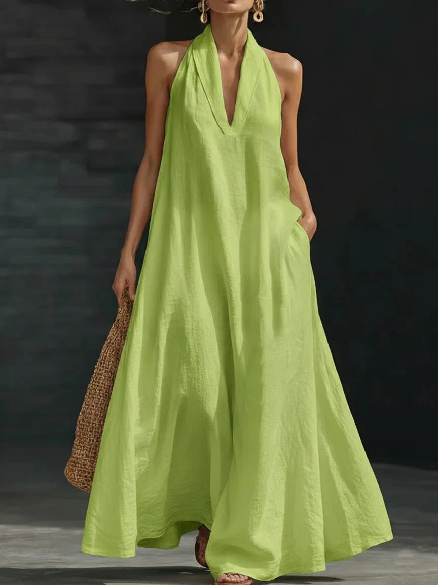 Linen-blend halter maxi dress with a fluid A-line skirt and side pockets, styled for warm weather.