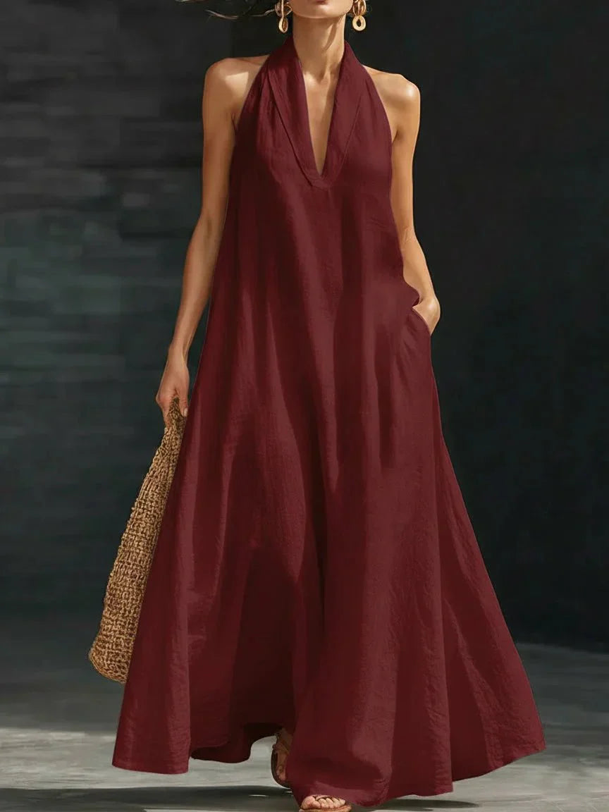 Linen-blend halter maxi dress with a fluid A-line skirt and side pockets, styled for warm weather.