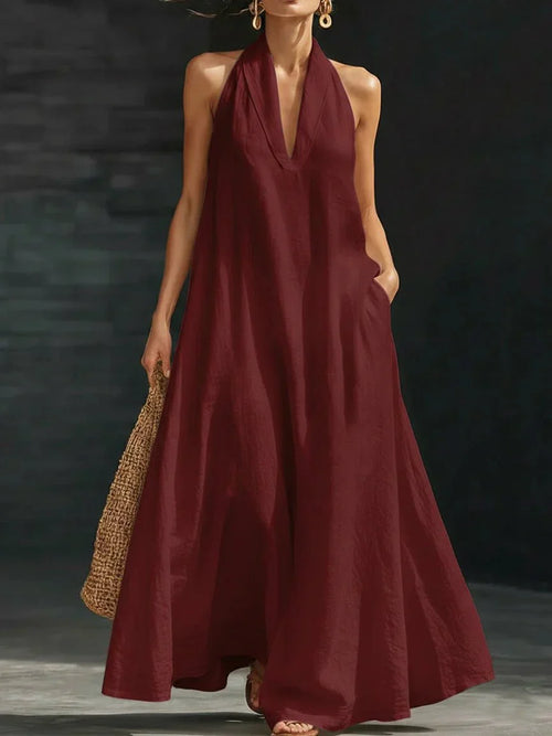 Linen-blend halter maxi dress with a fluid A-line skirt and side pockets, styled for warm weather.